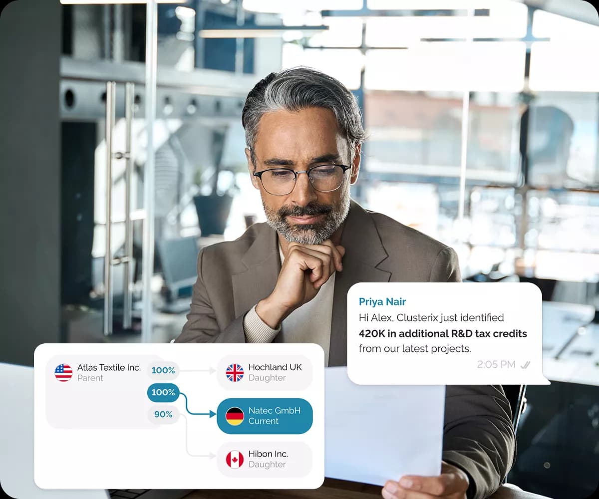 Professional man with glasses in business suit at modern office desk, with organizational structure diagram showing company hierarchy (Atlas Textile Inc as Parent with 100% ownership to Natec GmbH as Current, Hochland UK as Daughter, Hibon Inc as Daughter) and chat notification showing 420K in additional R&D tax credits identified